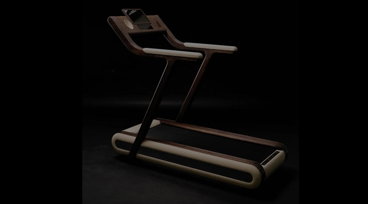 Treadmill angled against a near-black studio background with cream padded rails