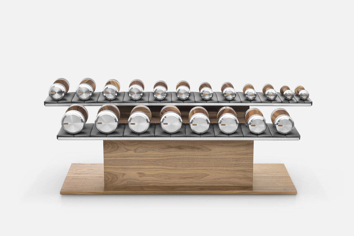 Two-tier rack holding rows of dumbbells with silver ends and wood-tone handles, studio shot