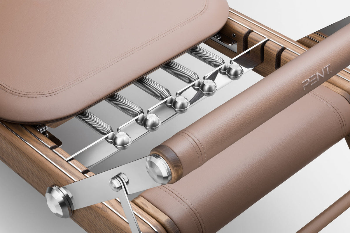 Close-up of the reformer tan padded surface with metal springs, rods and fittings