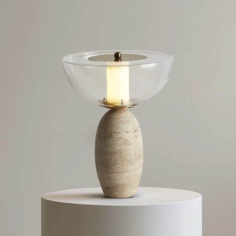 Table lamp with translucent bowl shade glowing warm over a speckled rounded base