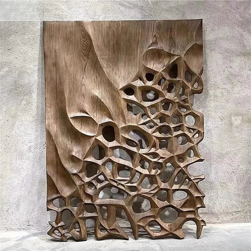 Tall carved brown wall panel with irregular openings and layered angular relief details