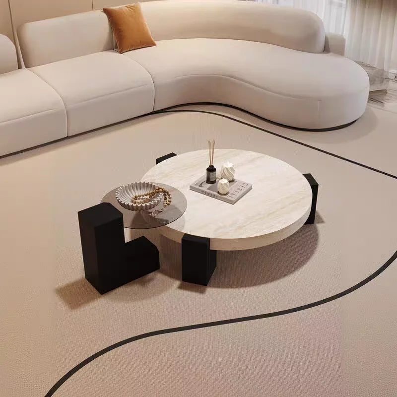 Travertine-finish coffee table with angular base paired with a glass side table in a styled living room