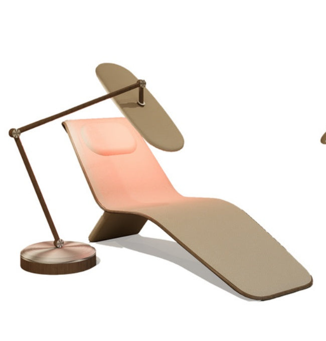Chaise lounge with tan curved surface and coral back panel beside a tan-shade floor lamp