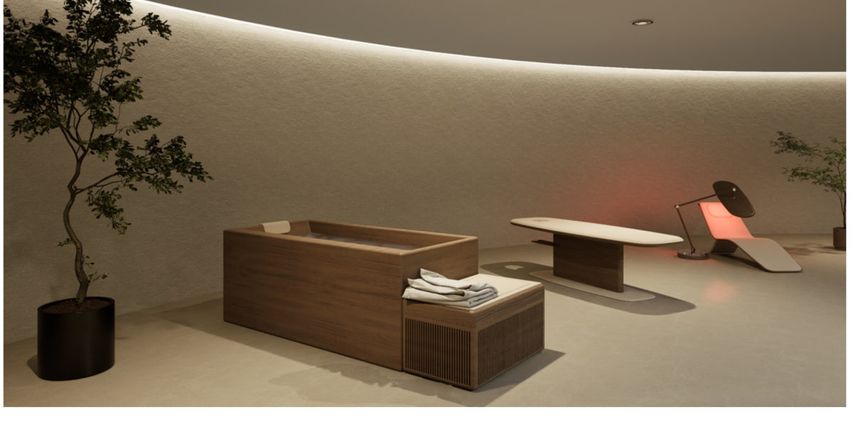 Dim spa room with a wood-grain tub, slatted bench with towels and a chair with lit backrest